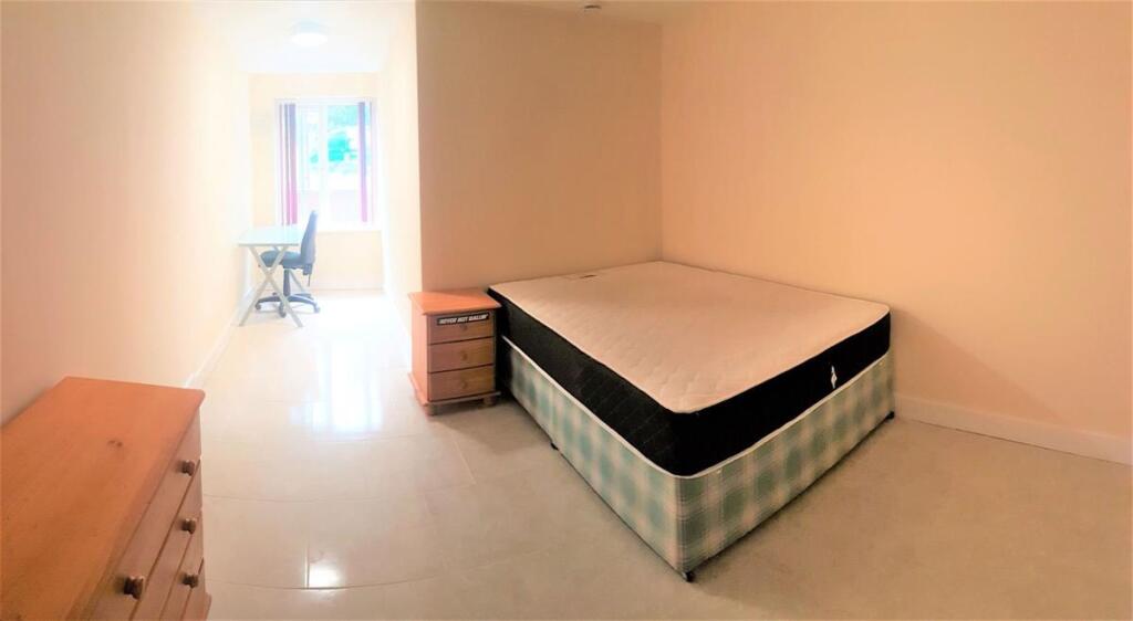 Bright, simply furnished double bedroom with a ...