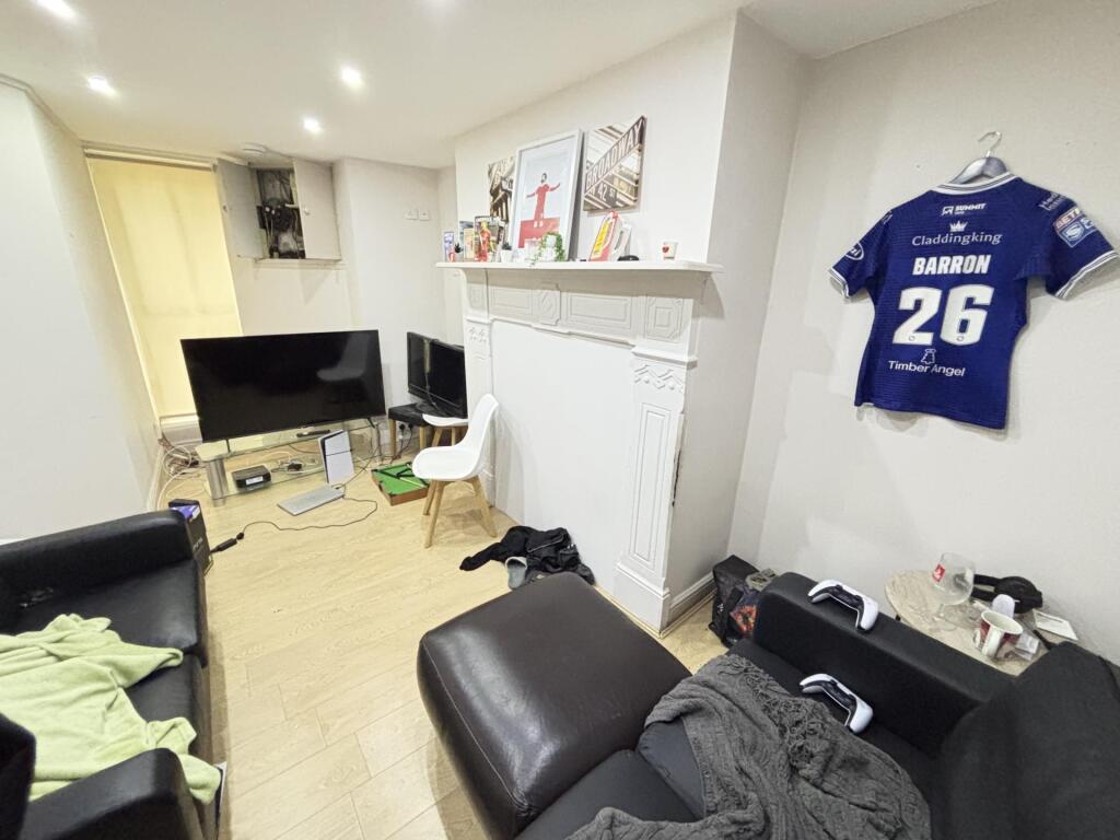 A cozy living room with a sofa, TV, and some pe...