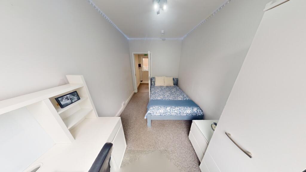 A neat and bright single bedroom featuring a si...