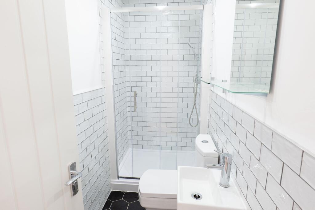 A modern, clean bathroom featuring white subway...