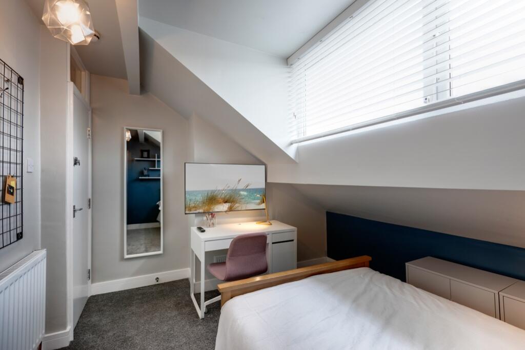 A bright, modern bedroom featuring a sloped cei...