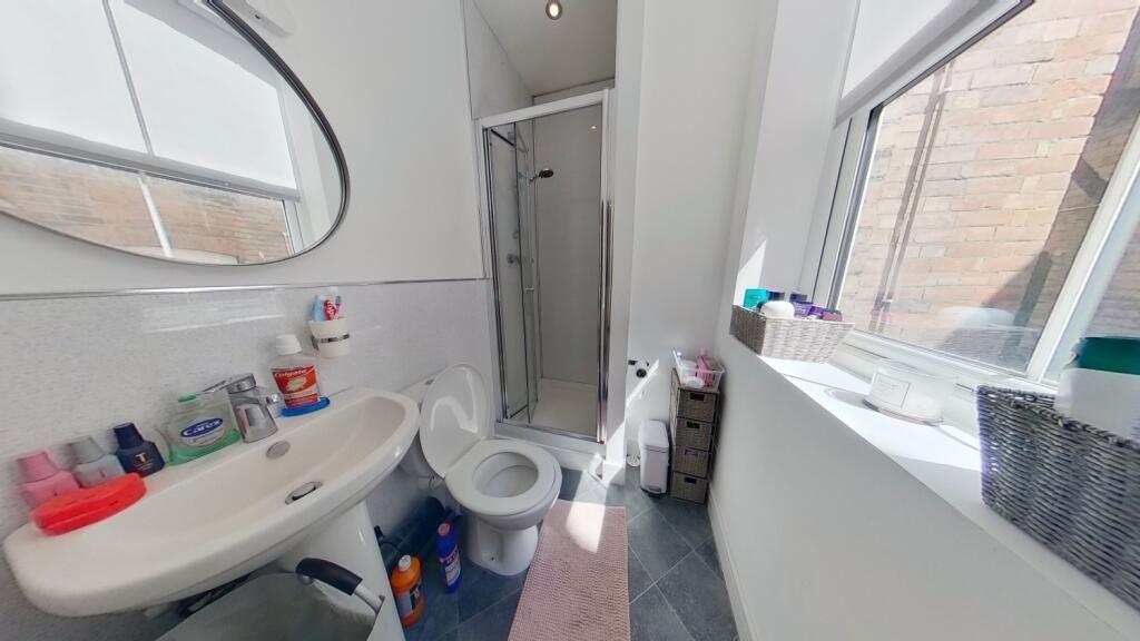 A bright bathroom featuring a large window that...