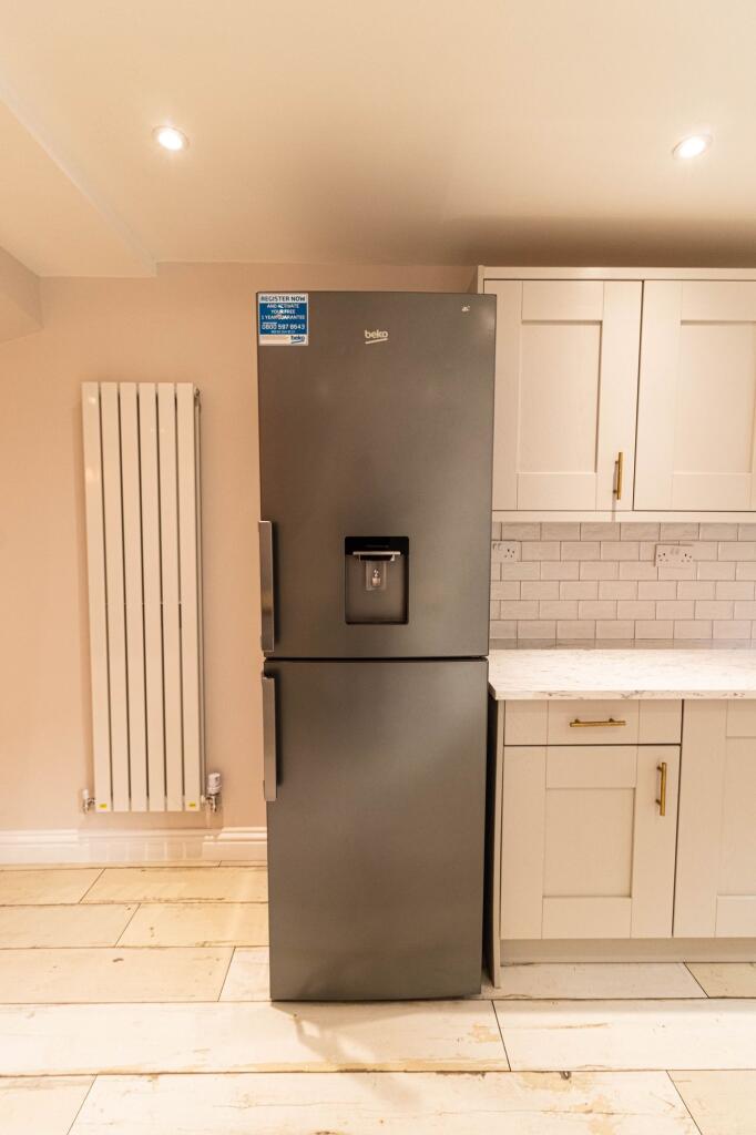 Modern kitchen with a sleek grey refrigerator a...