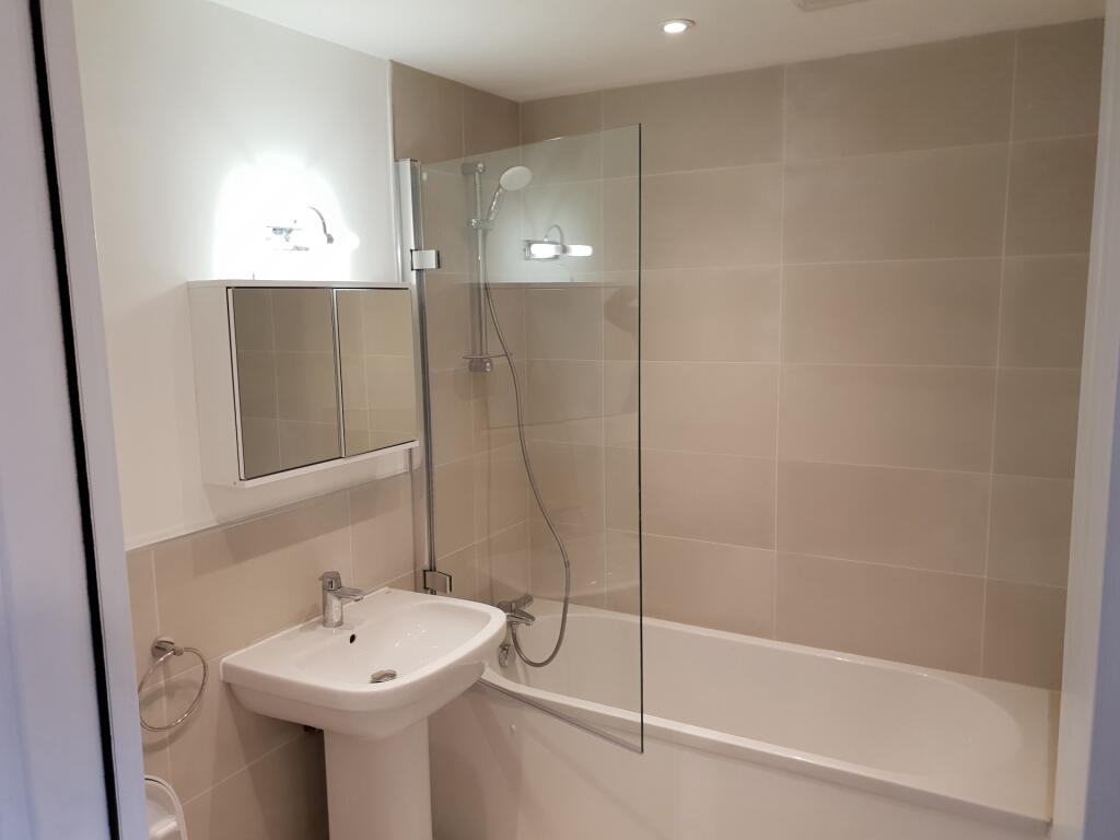 A modern bathroom suite featuring a clean white...