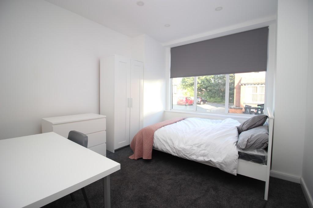 A clean and modern double bedroom featuring a l...