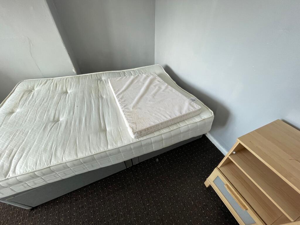 A simple single bedroom featuring a plain mattr...