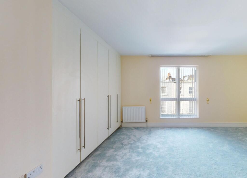 Bright and airy bedroom featuring built-in ward...