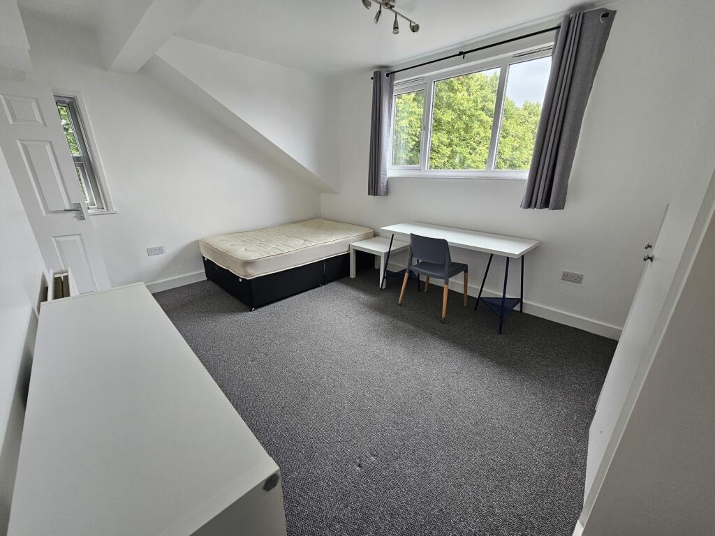 Bright and tidy bedroom featuring a large windo...