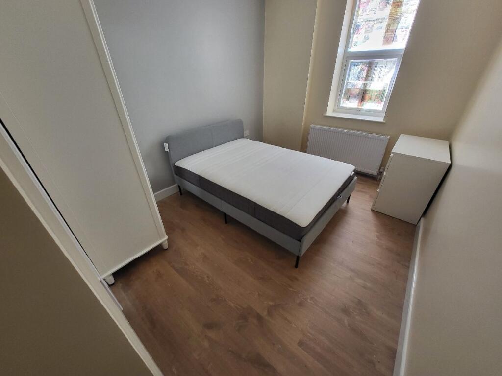 This cozy double bedroom features ample natural...