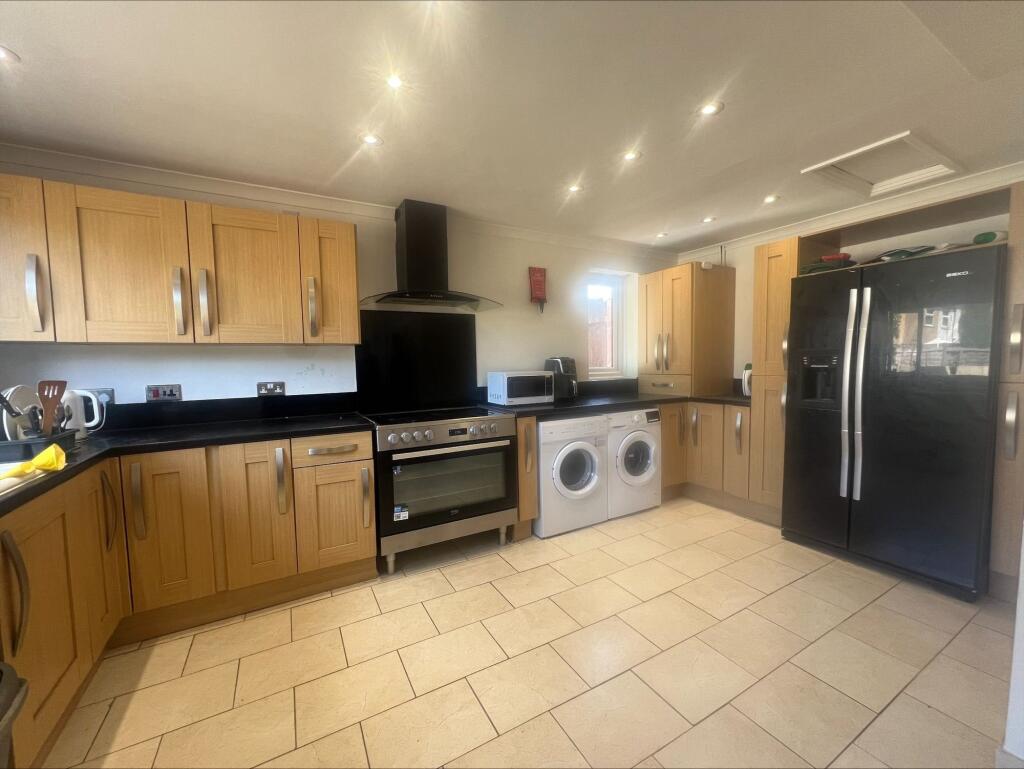 Bright and modern kitchen featuring ample woode...