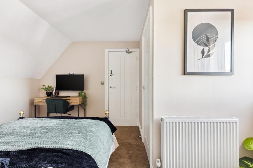 This cozy double bedroom features a stylish dec...