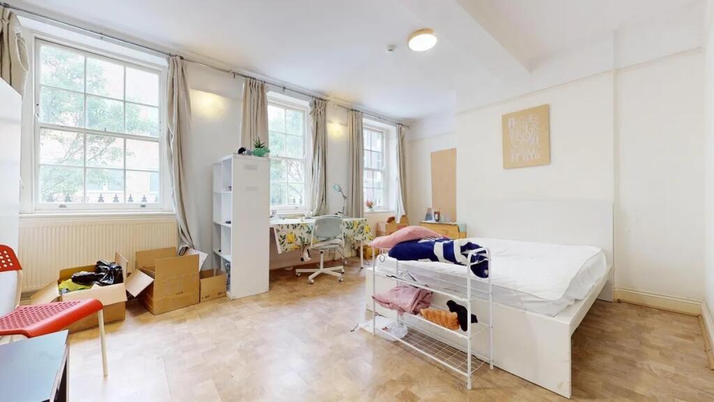 Bright and spacious bedroom featuring three lar...
