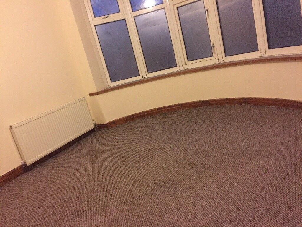 Bright corner bedroom with a bay window, neutra...