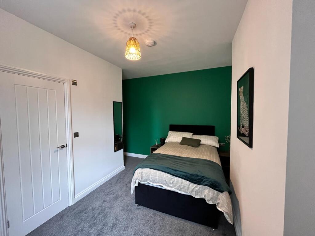 This inviting double bedroom features a cozy at...