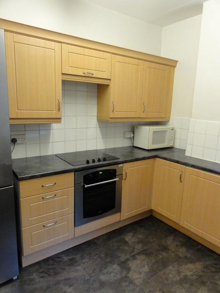 A functional kitchen with wooden cabinetry, a b...