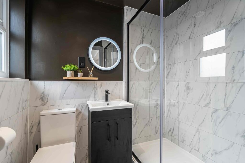 Modern and sleek bathroom featuring marble tile...