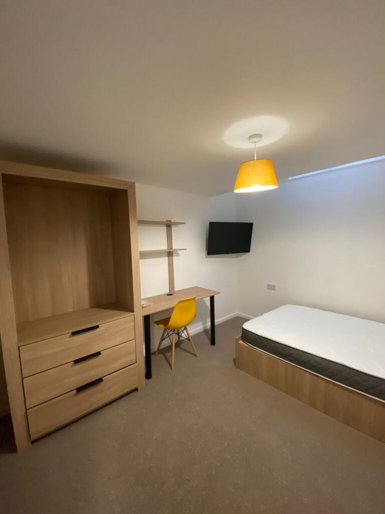 A modern double bedroom featuring a cozy bed, a...