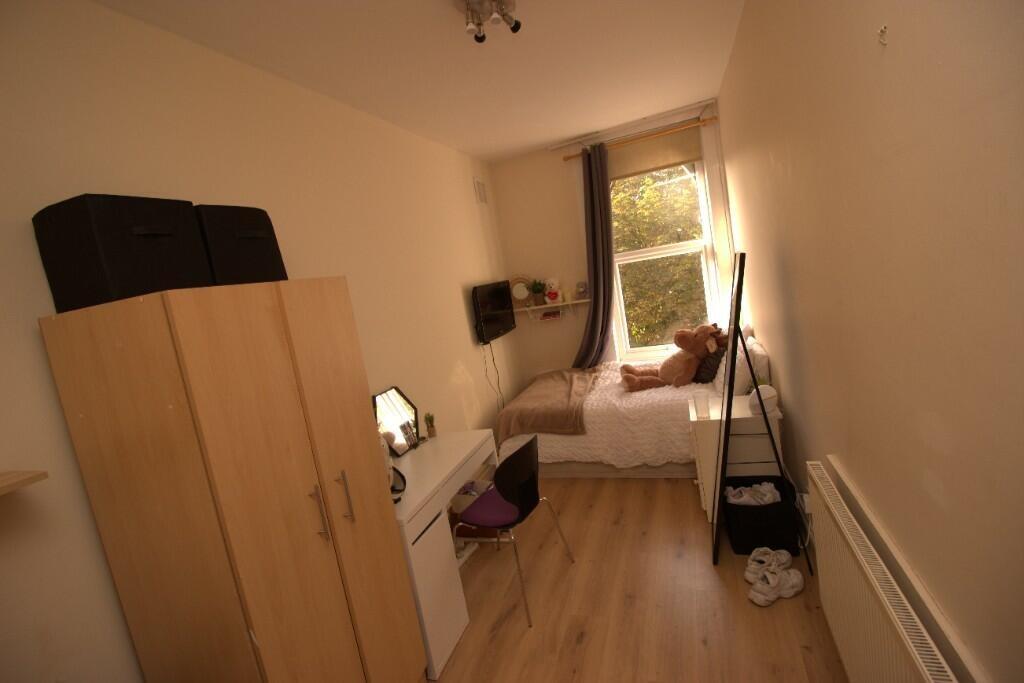A neat and cozy single bedroom with a window al...