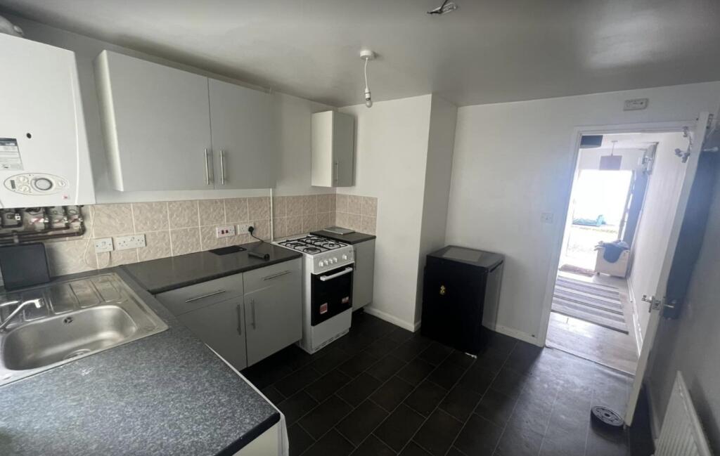 A small kitchen featuring a gas stove, sink, an...