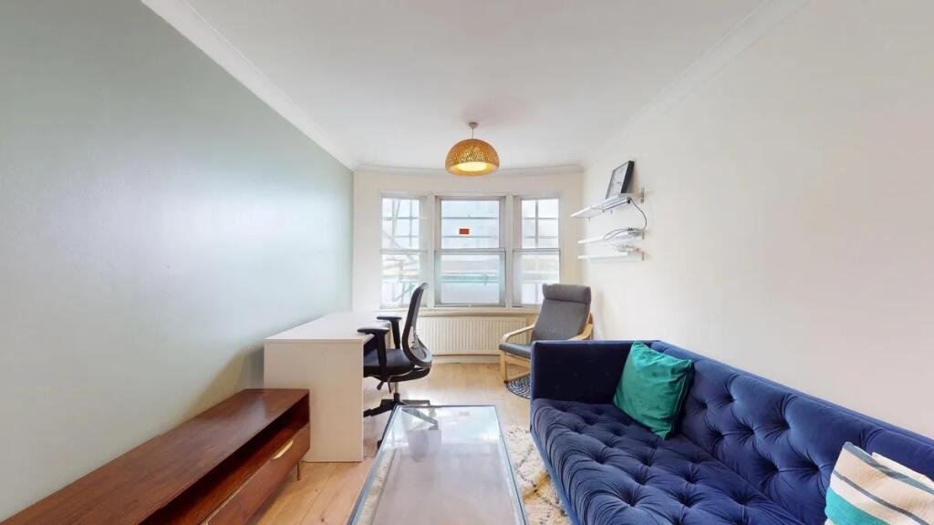 A bright and tidy living room featuring a cozy ...