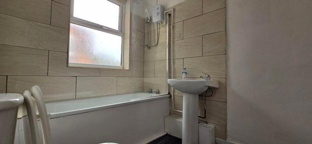 A spacious and bright bathroom featuring a comf...