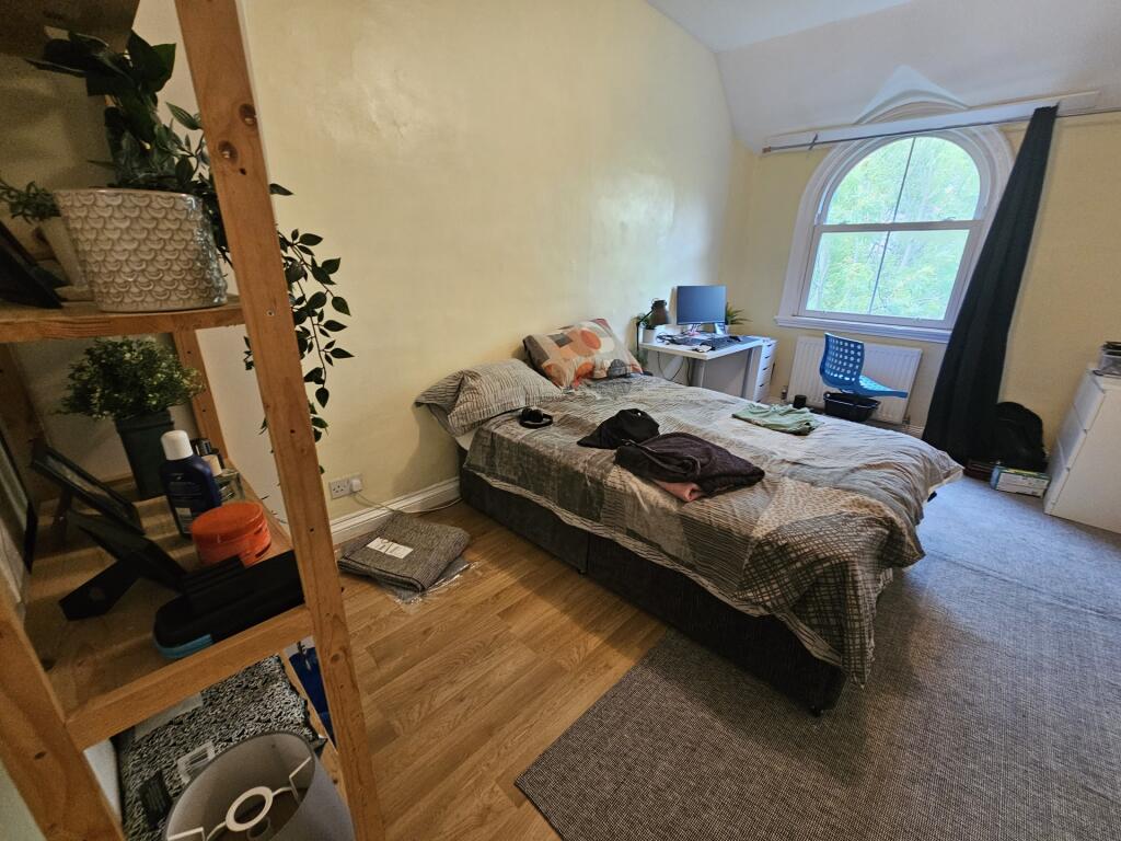 A bright and cozy bedroom featuring a comfortab...