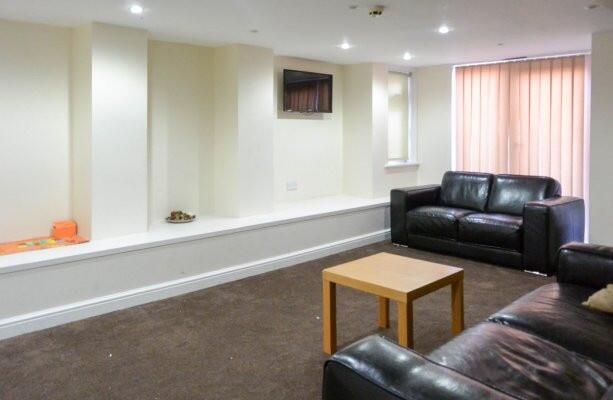 A modern living room with comfortable black lea...
