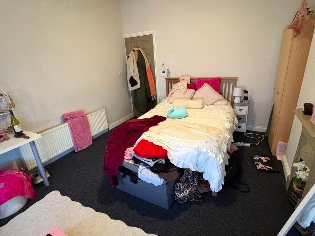 Cozy single bedroom featuring a comfortable bed...