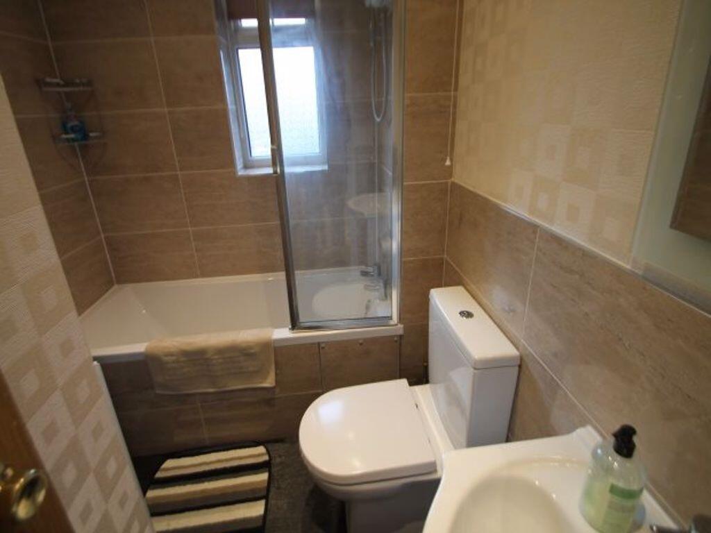 Well-presented bathroom with tiled walls, a com...