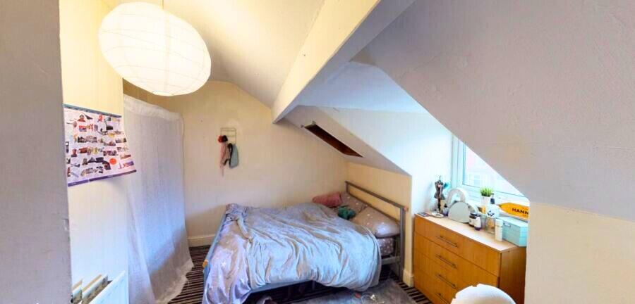 Cozy double bedroom with a sloped ceiling and a...