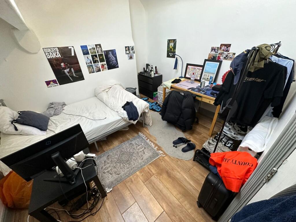 Brightly painted double bedroom with two beds, ...
