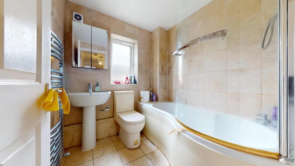 Bright and well-maintained bathroom suite featu...