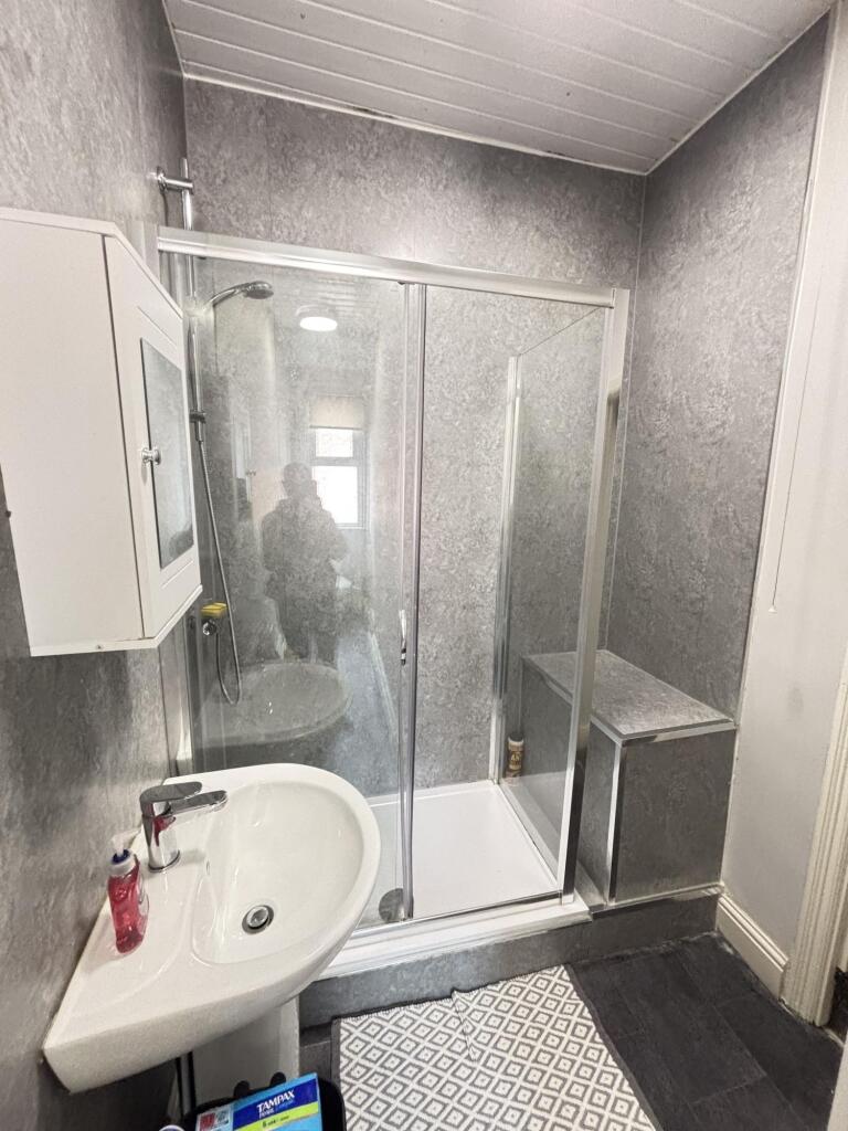 A tidy bathroom featuring a spacious shower enc...