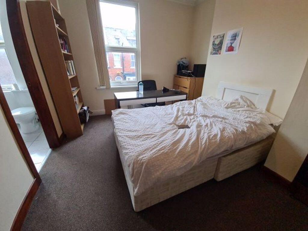 A bright and tidy bedroom featuring a double be...