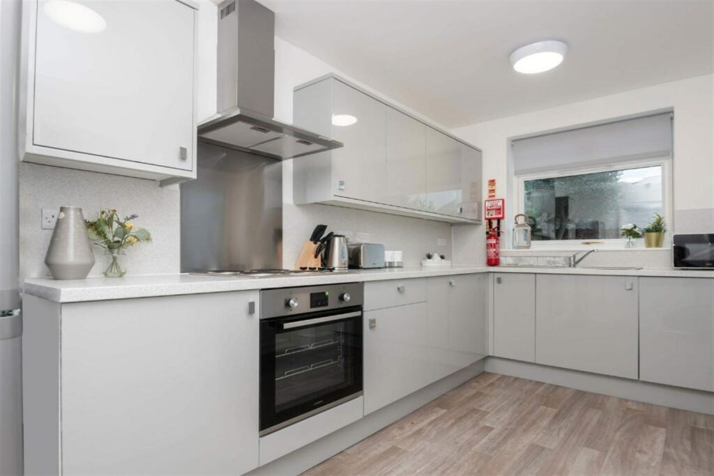 Bright and modern kitchen featuring sleek cabin...