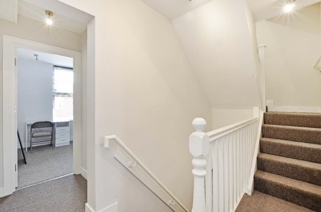 Bright and clean hallway with neutral decor and...