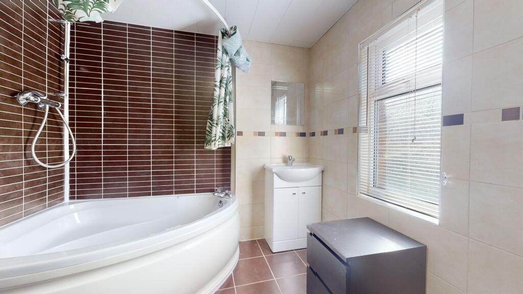 Bright and modern bathroom featuring a large ba...