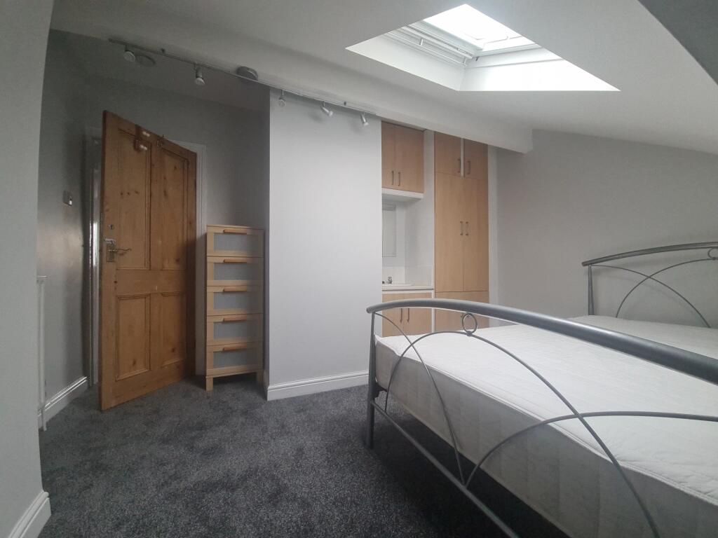 A clean, bright room with a skylight providing ...
