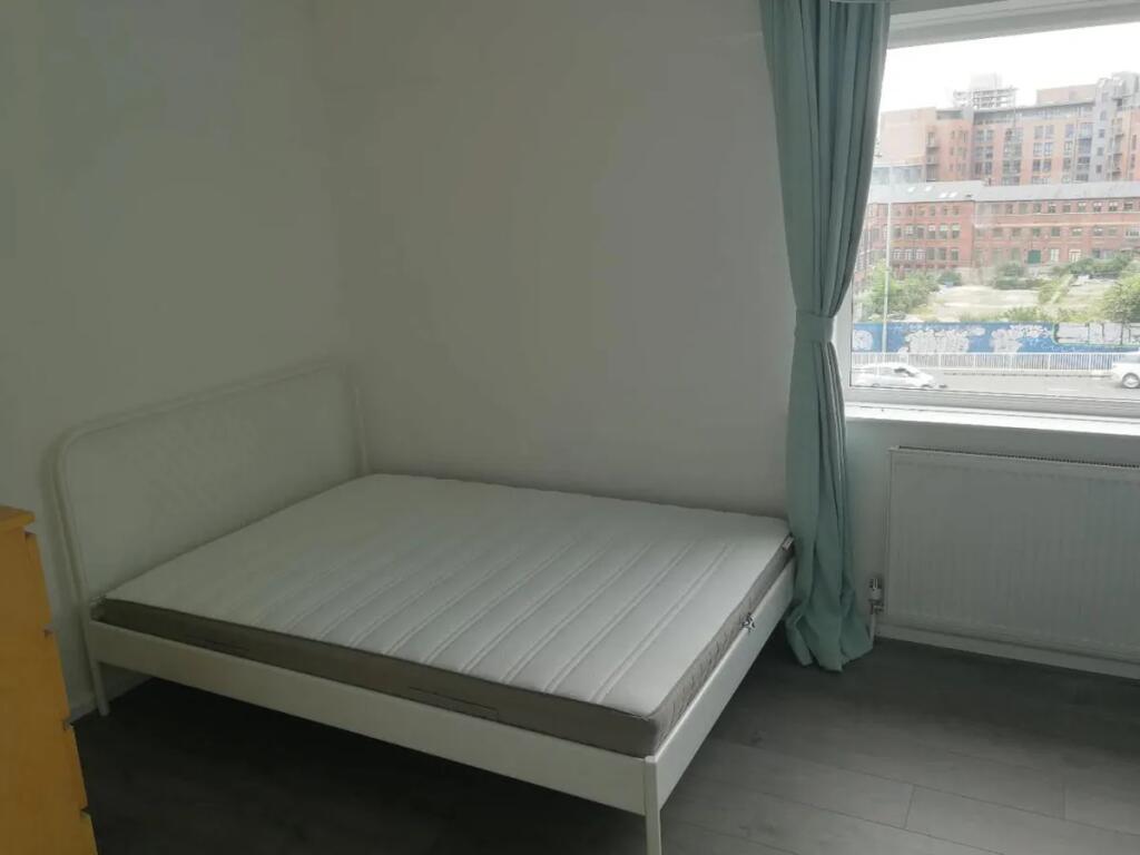 A neat double bedroom featuring a white metal b...