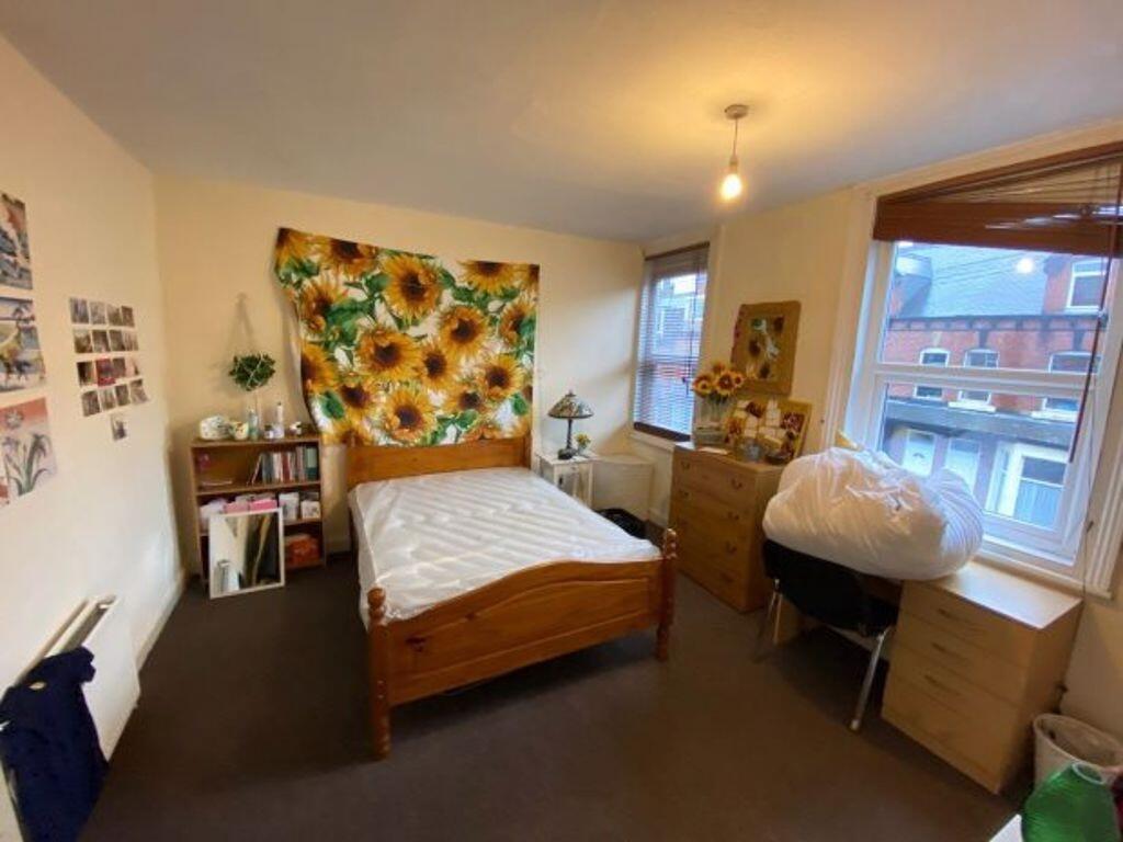 Bright, neatly arranged double bedroom with a w...