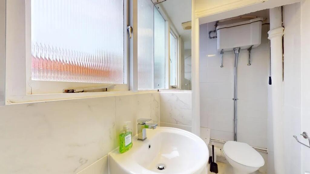 Bright and clean single toilet featuring a mode...