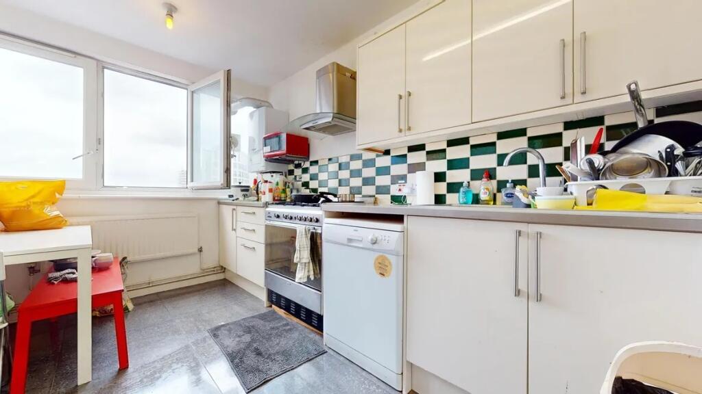 Bright kitchen featuring modern white cabinetry...