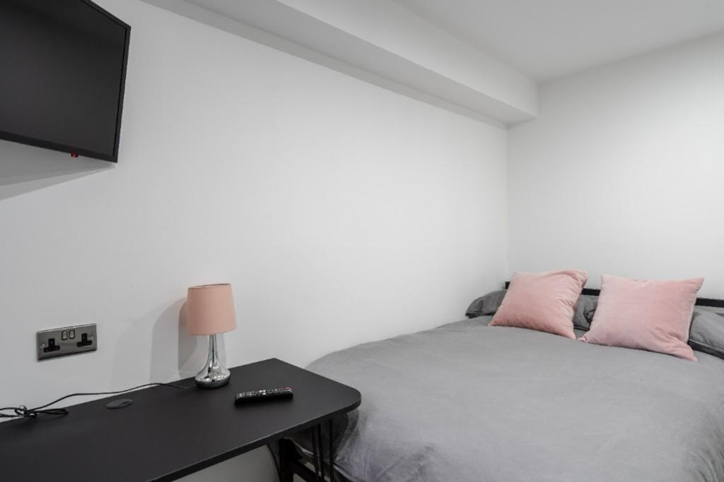 A modern double bedroom featuring a cozy bed an...