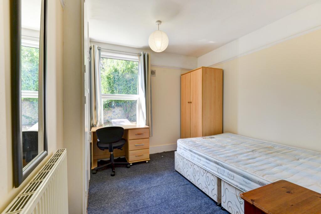 A bright and tidy double bedroom featuring a la...