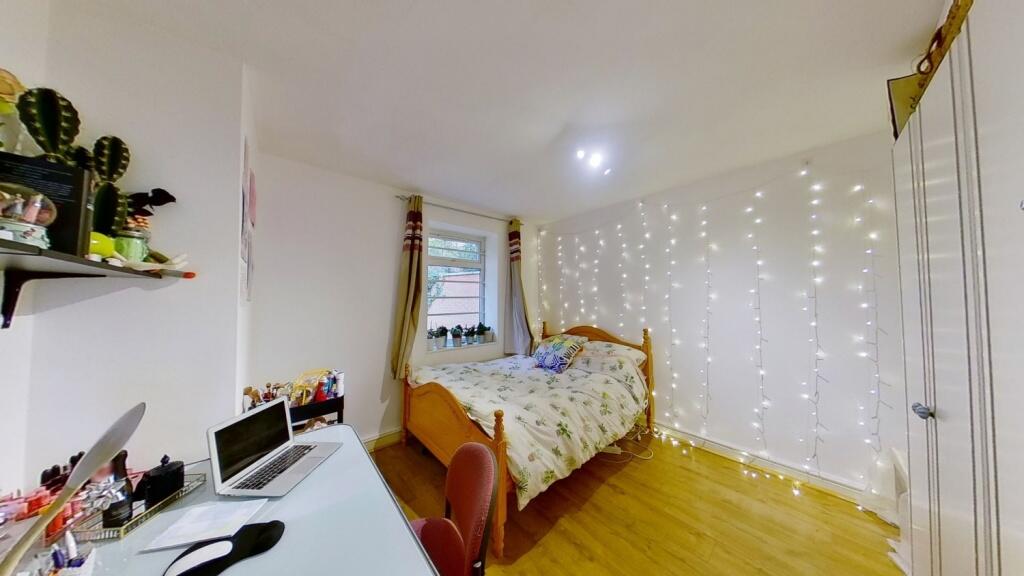 Bright and cozy single bedroom with a wooden fl...