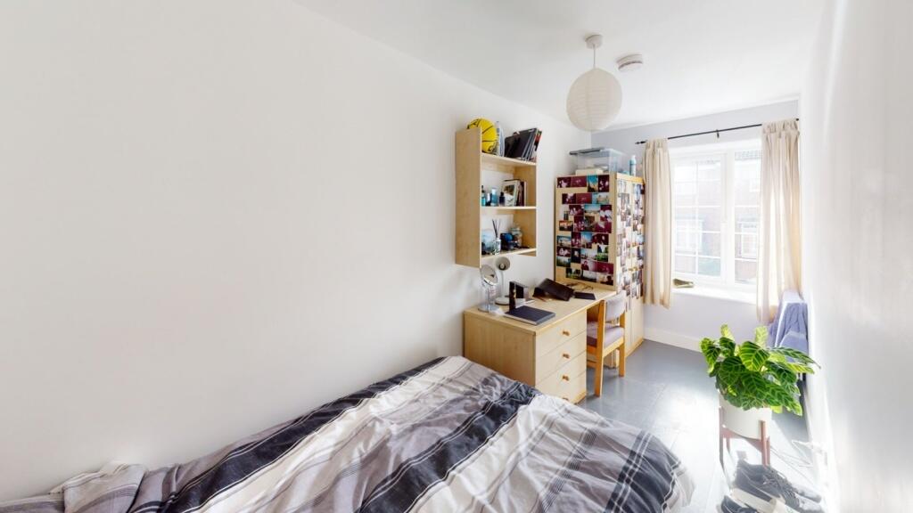 A bright and tidy single bedroom featuring a co...