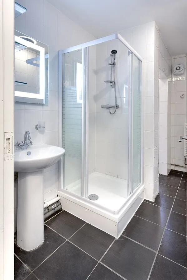 A modern bathroom featuring a bright shower enc...