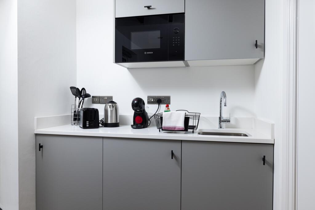 A modern kitchen featuring sleek cabinetry and ...