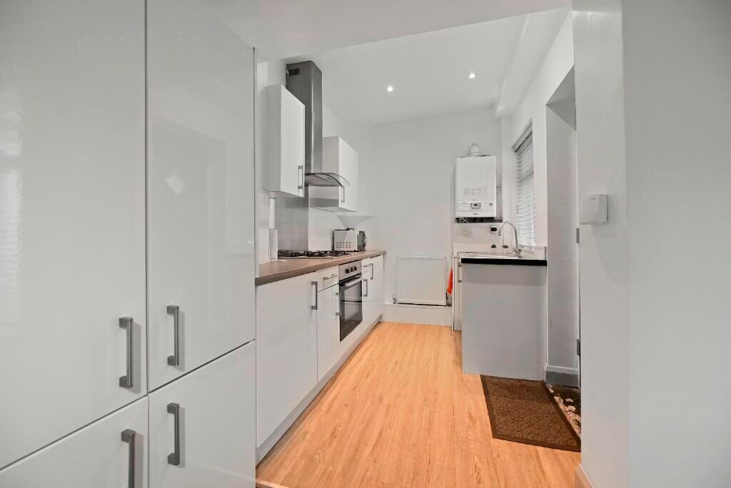 A modern, sleek kitchen with clean white cabine...