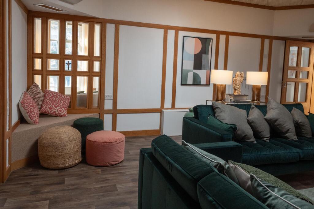 A stylish living room featuring plush dark gree...